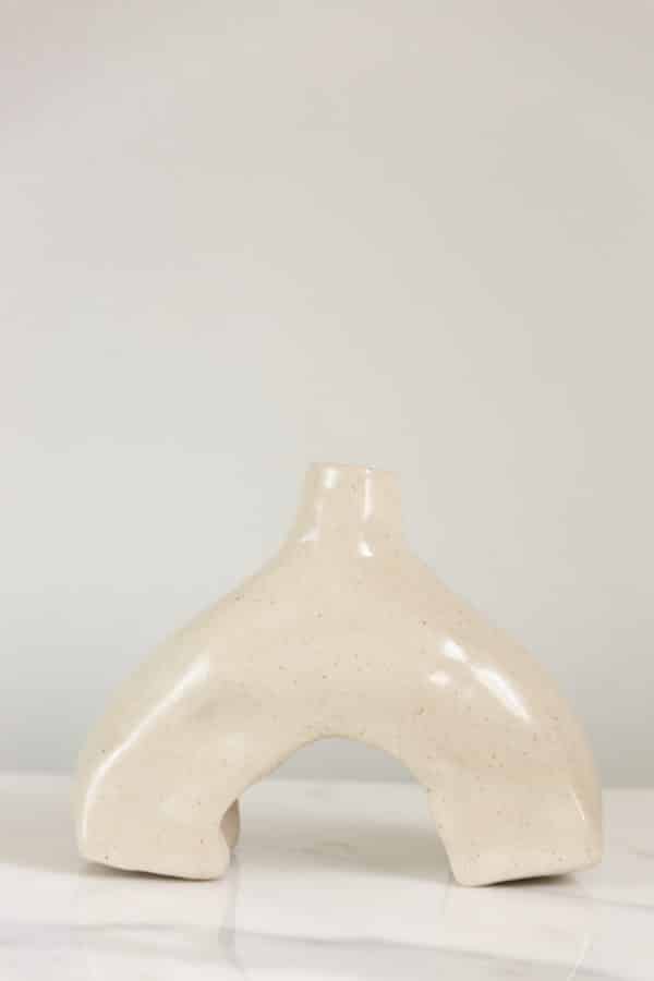 Small hand-built beige ceramic vase this is uniquely curved and a back view