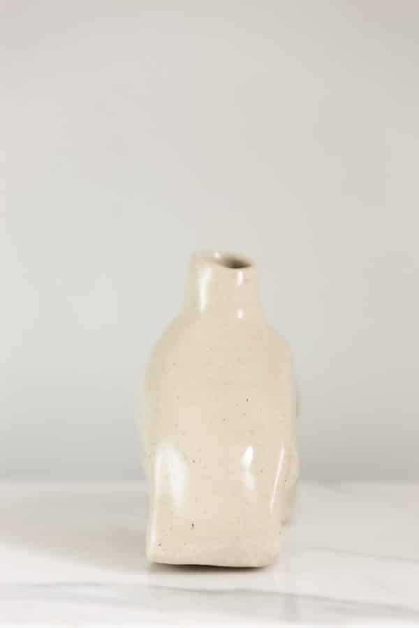 Small hand-built beige ceramic vase this is uniquely curved and a side view
