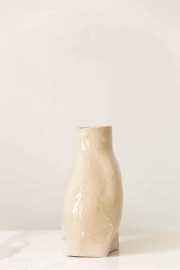 Large hand-built beige ceramic vase this is uniquely curved and a side view